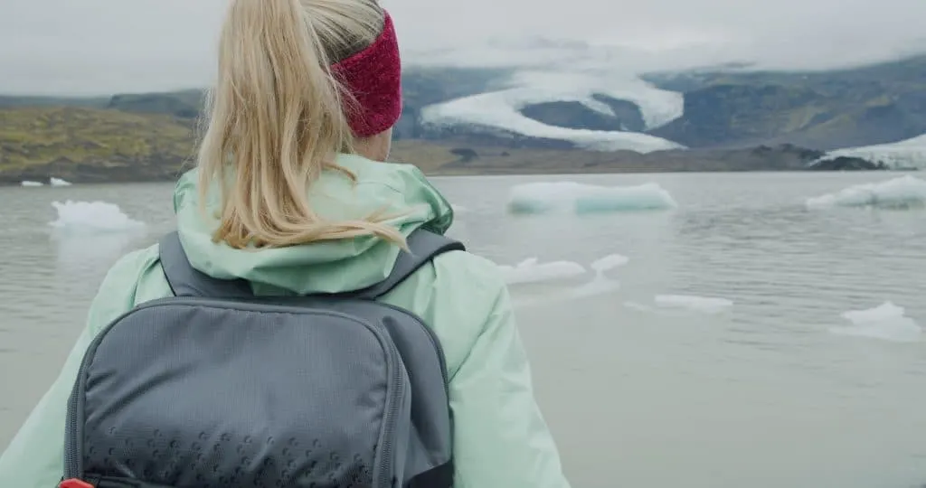 Woman visiting outdoors tourist destination landmark attraction Fjallsarlon glacial lagoon in